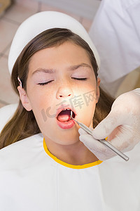 儿科牙医在牙医椅上检查病人的牙齿