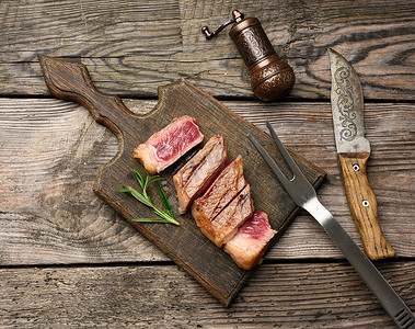 切片炸牛排纽约腰肉放在木板上，熟度很少