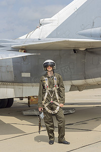 头盔的军事飞行员站在喷气式飞机附近