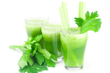 芹菜汁摄影照片_芹菜和三杯用白色隔离的芹菜汁