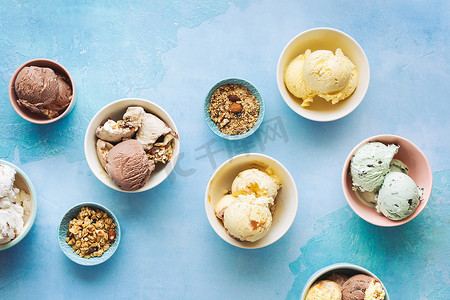 质朴的蓝色背景、顶视图、空白空间中碗中的各种冰淇淋甜点