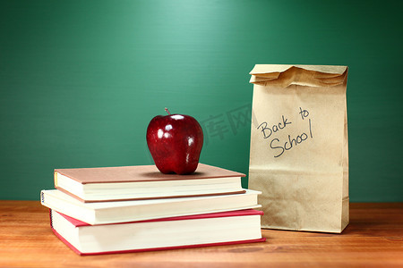 教师桌上的书籍、苹果和午餐