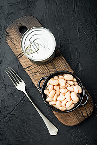 白罐装豆子，金属罐头，碗里，黑石背景，顶视图平躺