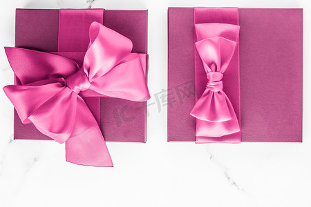 礼盒展示摄影照片_大理石背景上带丝绸蝴蝶结的粉红色礼盒、女婴淋浴礼物和奢华美容品牌的魅力时尚礼物、假日平板艺术设计