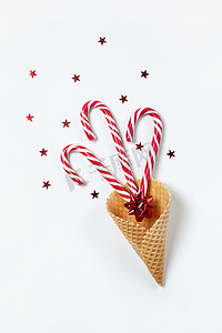 圣诞作曲三个焦糖棒棒糖和华夫饼干中的蝴蝶结，白色背景上的五彩纸屑星。