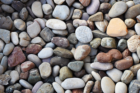 五颜六色的灯关摄影照片_海边沙滩上美丽的五颜六色的石头。