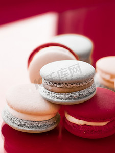 酒广告摄影照片_酒红色背景的法式马卡龙、巴黎别致的咖啡甜点、甜食和豪华糖果品牌的蛋糕马卡龙、假日背景设计