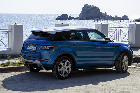 汽车是黑色海堤上的蓝色路虎揽胜极光。