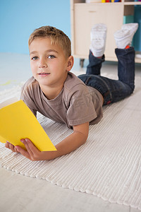 男孩在教室看书摄影照片_坐在地上看书的可爱小男孩