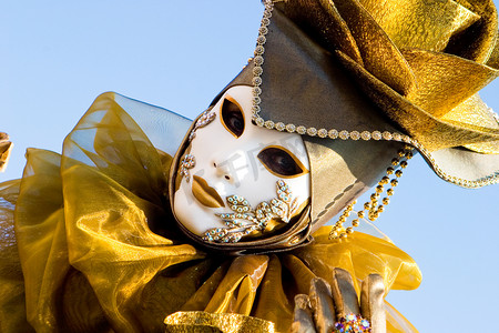 一位身穿金色服装、戴着白色面具的威尼斯女人