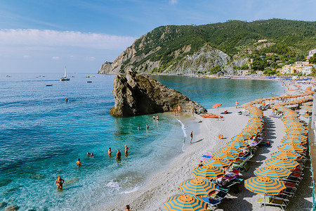 椅子和遮阳伞填满了 spiaggia di fegina 海滩，这是意大利 Monterosso 宽阔的沙滩村，是意大利五渔村的一部分