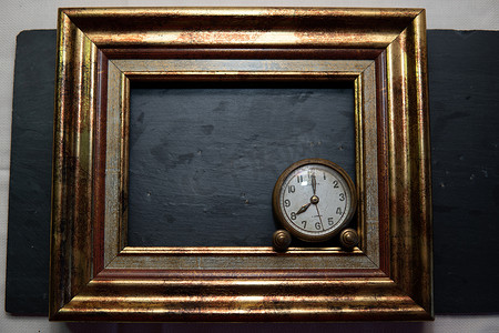 黑色石板背景和标记中的古董钟