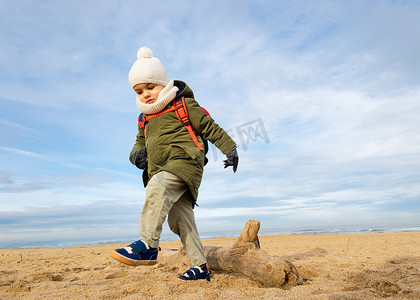 走在海滩的小男孩，冬天