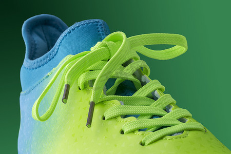 绿色背景上的绿色蓝色运动鞋。