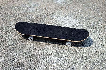 水泥地面上的黑色滑板。