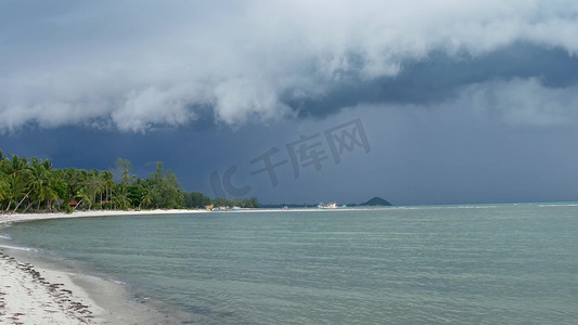 台风摄影照片_在潮湿的雨季，泰国苏梅岛的沙质海岸挥舞着蓝色的大海。