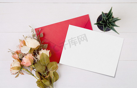 情人节，贺卡模型和木制桌子上的字母和花朵，空白明信片和桌上浪漫的礼物，在周年纪念和庆祝活动中呈现，顶视图，节日概念。