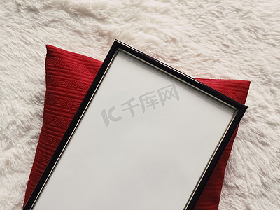 艺术框摄影照片_带有空白复制空间的黑色薄木框作为海报照片打印模型、红色垫枕和蓬松的白色毯子、平躺背景和艺术产品