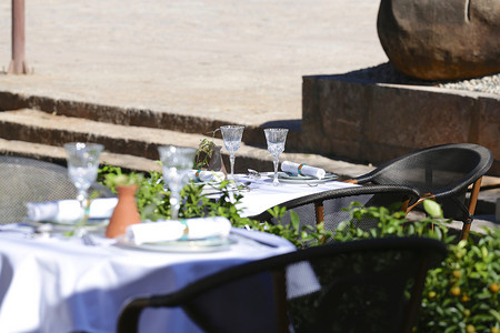露台餐厅摄影照片_带桌椅的露台餐厅环境被绿色植物包围。