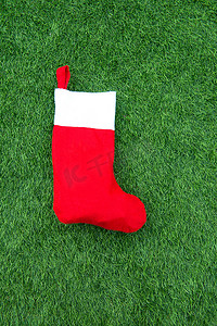 挂圣诞袜摄影照片_绿草地上的圣诞袜