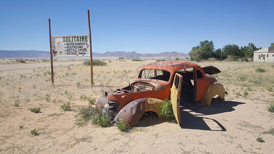 车在沙漠摄影照片_在加油站接龙的旧车残骸