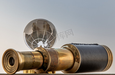老式双筒望远镜和水晶球与天空背景。