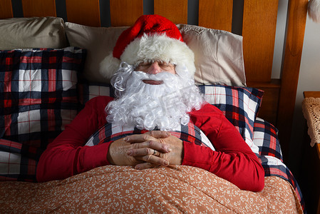 圣诞老人在他平安夜分娩后，睡在北极的床上，双手交叉放在胸前。
