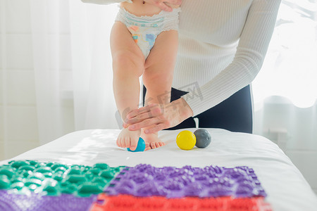 妈妈用按摩球给宝宝做足部按摩。