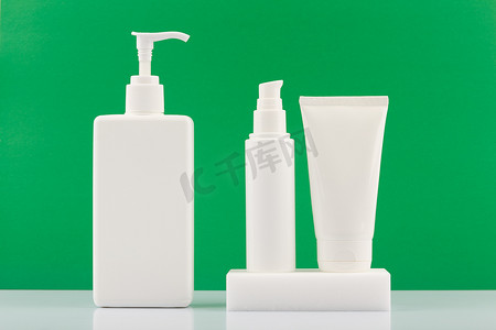 绿色背景下白色无品牌管装护肤美容产品套装。