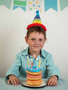 快乐男孩和带蜡烛的生日甜甜圈蛋糕