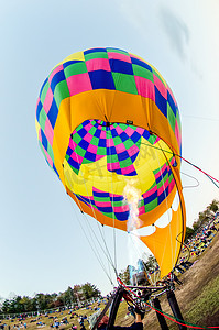 加热空气摄影照片_在热气球节上，火加热了热气球内的空气