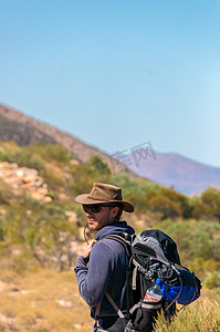 徒步登上澳大利亚西麦克唐纳国家公园爱丽丝泉外桑德山顶后欣赏美景的男子