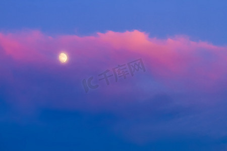 蓝天下粉红色云朵下的月亮