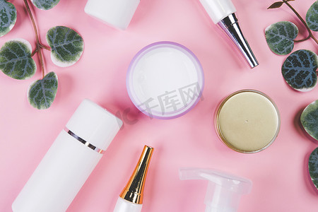 带奶油或乳液和叶子的化妆品瓶模型隔离在粉红色背景中，用于广告、护肤或美容的模型包装、顶视图、平躺、皮肤护理和产品治疗。