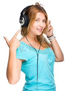 听音乐背景摄影照片_音乐和技术概念 — 年轻女性在耳机上听音乐和表演，被白色隔离