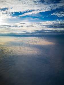 从飞机到云层上的早晨日出的鸟瞰图