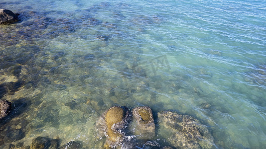在多石的海底从水里取出岩石的空中