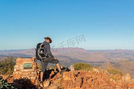 徒步登上澳大利亚西麦克唐纳国家公园爱丽丝泉外桑德山顶后欣赏美景的男子