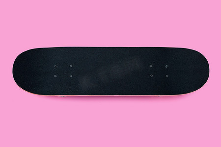 粉红色背景上的黑色滑板。