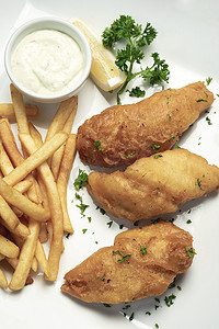 炸鱼薯条摄影照片_盘子里的英国传统炸鱼薯条餐
