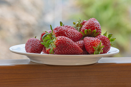 洗草莓草莓摄影照片_在盘子上的红色成熟草莓。