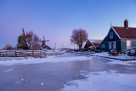 风车雪摄影照片_Zaanse Schans 风车村冬季雪景，雪覆盖的木制历史风车 Zaanse Schans Netherlands Holland