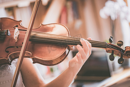 练习古典音乐和小提琴概念：小女孩愉快地拉着她的新小提琴