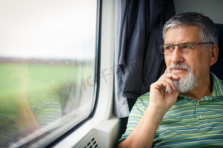 旅行的老人摄影照片_享受火车旅行的老人