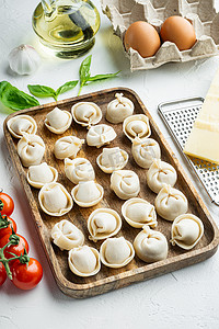 意大利饺子配帕尔马干酪和罗勒，放在木盘里，白色背景