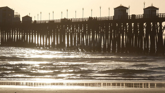 在堆的木码头，在日落的剪影，美国加利福尼亚州，海边。