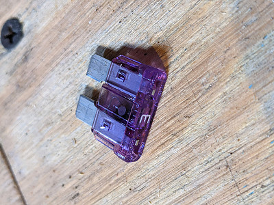 飞木背景上的紫色 5 安培保险丝