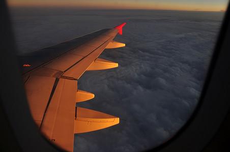 飞机上的金色光云，从飞机上看，在金色的夕阳照亮空气中，雄伟的云彩飞翔