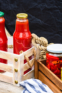 装有腌制红甜椒的玻璃罐和装有西红柿酱的瓶子，采用质朴的成分。