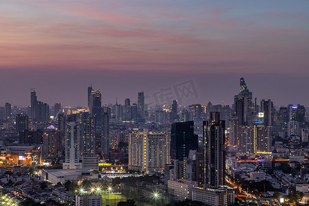傍晚的天空摄影照片_曼谷的天空景观与曼谷商业区的摩天大楼在傍晚美丽的暮色中赋予这座城市现代风格。
